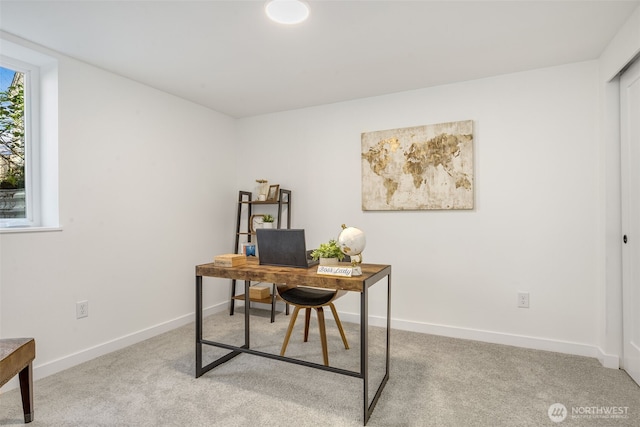 carpeted home office featuring baseboards