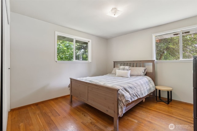 8511 31st St W, University Place, WA 98466 - bedroom featuring multiple windows, light wood-style floors, and baseboards