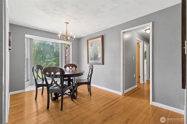 8511 31st St W, University Place, WA 98466 - dining space with light wood-type flooring, baseboards, and a chandelier
