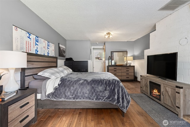 8511 31st St W, University Place, WA 98466 - bedroom with hardwood / wood-style flooring, a textured ceiling, and a fireplace