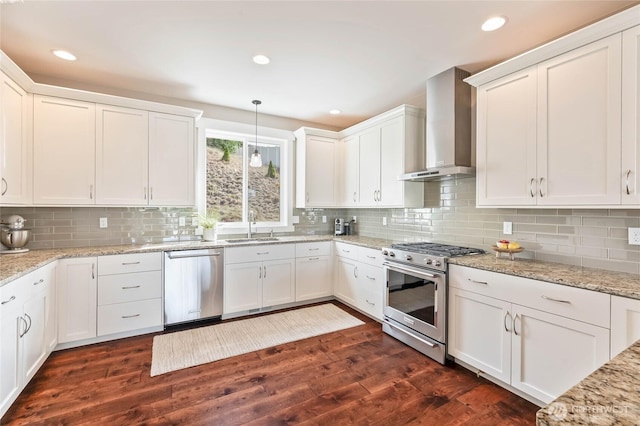 719 19th St NE, East Wenatchee, WA 98802 - kitchen featuring appliances with stainless steel finishes, wall chimney range hood, white cabinets, dark wood-style flooring, and a sink