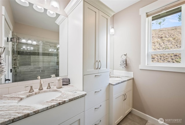 719 19th St NE, East Wenatchee, WA 98802 - bathroom with a stall shower, two vanities, tile patterned floors, and baseboards