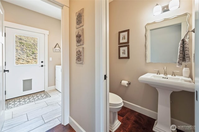 719 19th St NE, East Wenatchee, WA 98802 - bathroom with washer / clothes dryer, wood finished floors, toilet, and baseboards