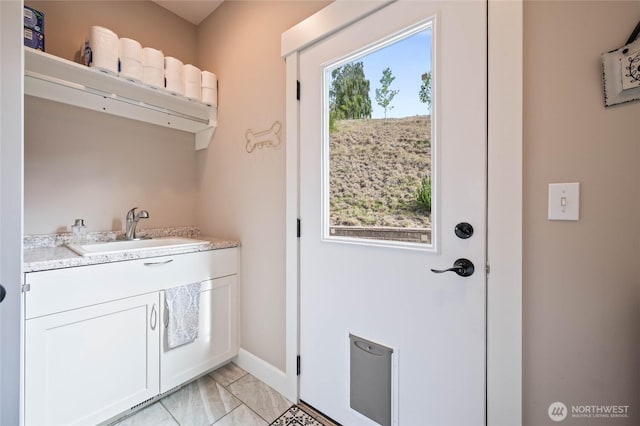 719 19th St NE, East Wenatchee, WA 98802 - washroom featuring a sink, baseboards, and light marble finish flooring