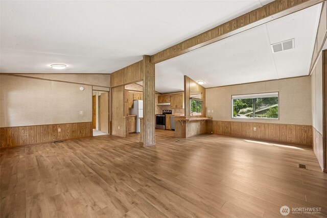 23920 50th Ave E, Graham, WA 98338 - unfurnished living room featuring wood walls, lofted ceiling, wood finished floors, and wainscoting