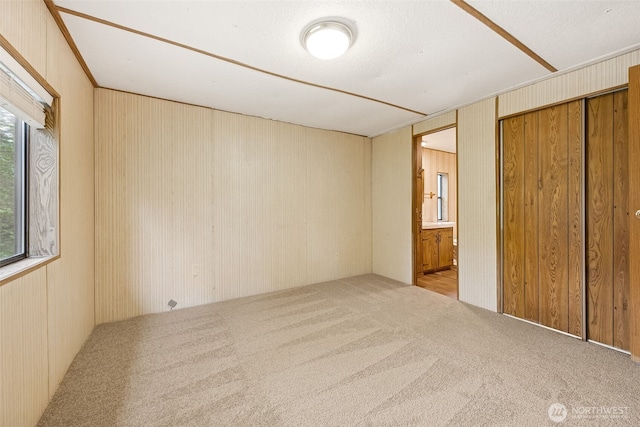 23920 50th Ave E, Graham, WA 98338 - unfurnished bedroom featuring carpet floors, wood walls, and connected bathroom