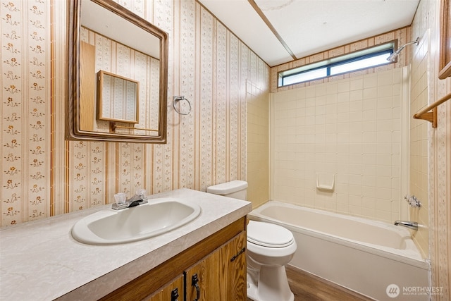 23920 50th Ave E, Graham, WA 98338 - bathroom featuring toilet, wood finished floors, vanity, wallpapered walls, and tub / shower combination
