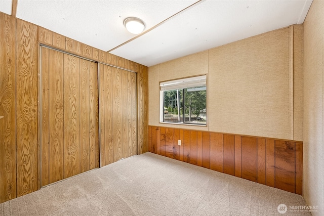 23920 50th Ave E, Graham, WA 98338 - unfurnished bedroom featuring wood walls, carpet flooring, and a closet