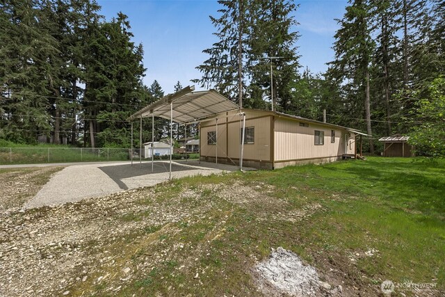23920 50th Ave E, Graham, WA 98338 - back of property featuring a shed, gravel driveway, a detached carport, and an outbuilding