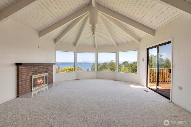 unfurnished living room with carpet floors, a water view, healthy amount of natural light, and a fireplace