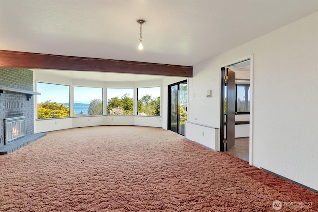 unfurnished living room featuring carpet, beam ceiling, and a fireplace