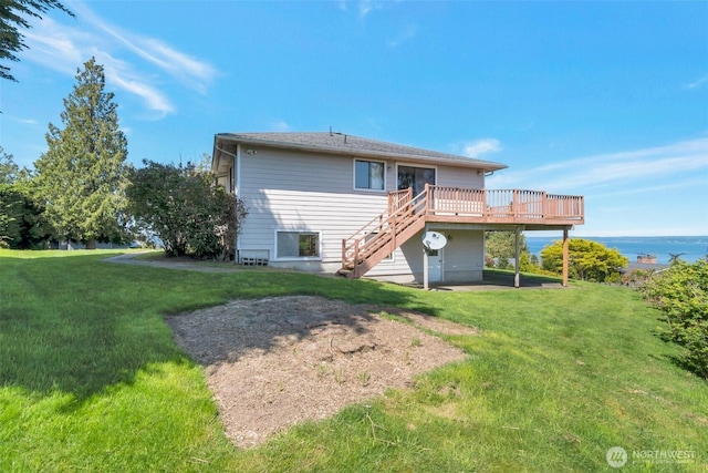 rear view of property featuring a deck with water view, stairway, and a yard