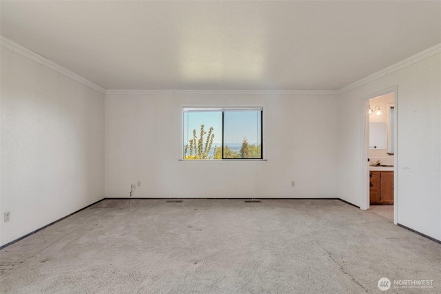 spare room with crown molding, light colored carpet, and baseboards