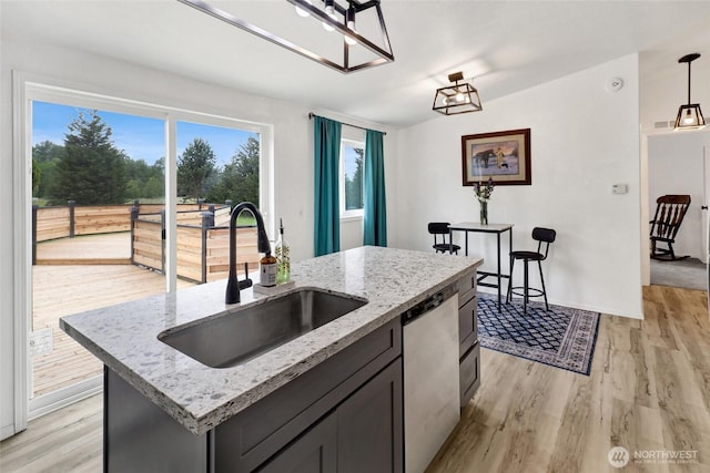 7135 W 40th Dr, Ferndale, WA 98248 - kitchen with a sink, dishwasher, light wood-style floors, hanging light fixtures, and light stone countertops