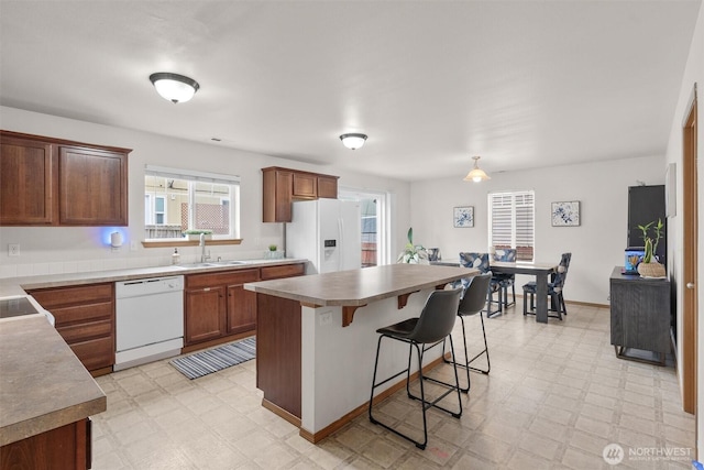 9604 201st Street Ct E, Graham, WA 98338 - kitchen featuring white appliances, light flooring, a kitchen bar, and a center island