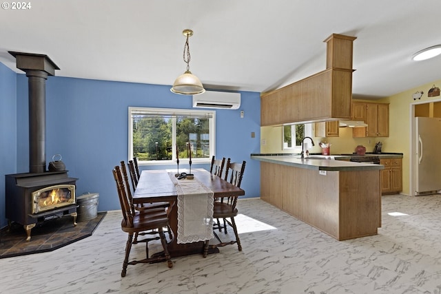 632 Meier Rd, Winlock, WA 98596 - dining area featuring a wall unit AC, plenty of natural light, a wood stove, lofted ceiling, and light marble finish floors