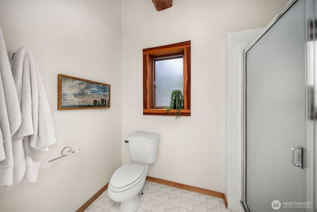full bath with baseboards, a shower stall, and toilet