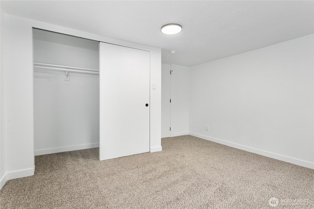 unfurnished bedroom featuring carpet flooring, a closet, and baseboards