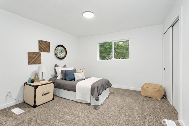 carpeted bedroom with baseboards and a closet
