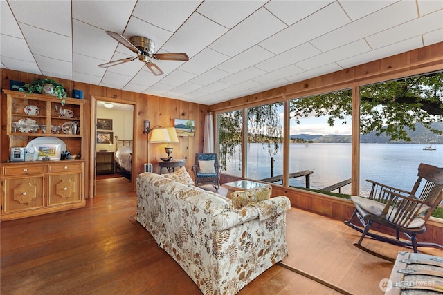 11194 S Lakeshore Rd, Chelan, WA 98816 - living room featuring ceiling fan, healthy amount of natural light, wooden walls, a water view, and wood finished floors
