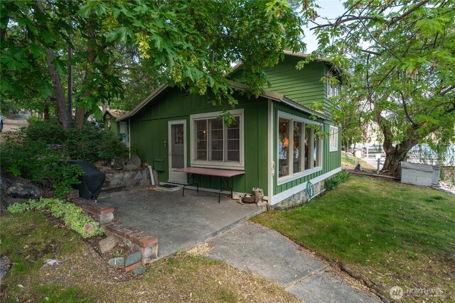 11194 S Lakeshore Rd, Chelan, WA 98816 - view of home's exterior with a patio area, a yard, and board and batten siding