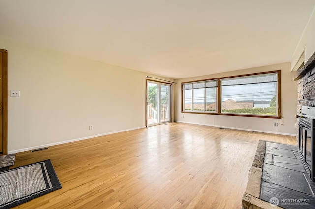 1204 S 229th St, Des Moines, WA 98198 - unfurnished living room with a glass covered fireplace, light wood-type flooring, and baseboards