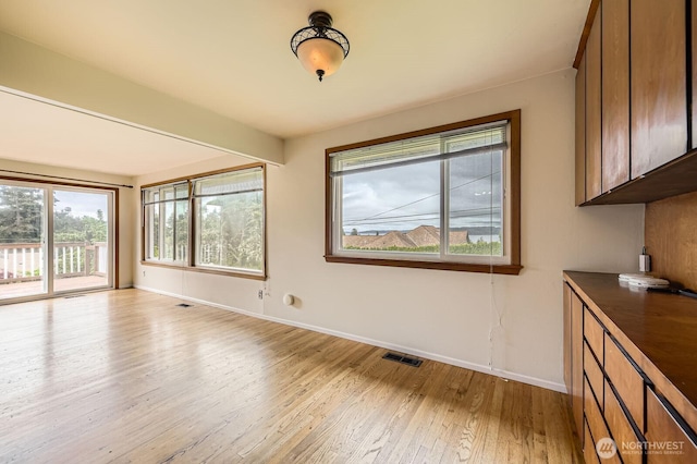 1204 S 229th St, Des Moines, WA 98198 - unfurnished dining area featuring light wood-style flooring and baseboards