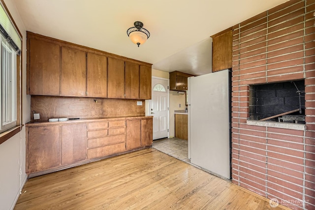 1204 S 229th St, Des Moines, WA 98198 - kitchen featuring freestanding refrigerator, brown cabinetry, and light wood finished floors