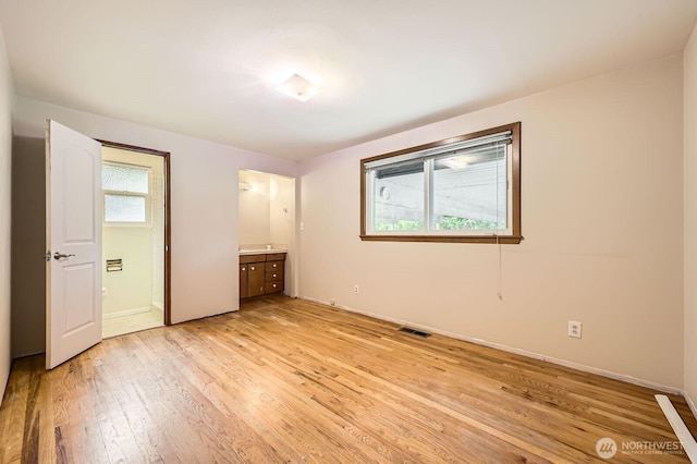 1204 S 229th St, Des Moines, WA 98198 - unfurnished bedroom featuring light wood finished floors, connected bathroom, and baseboards