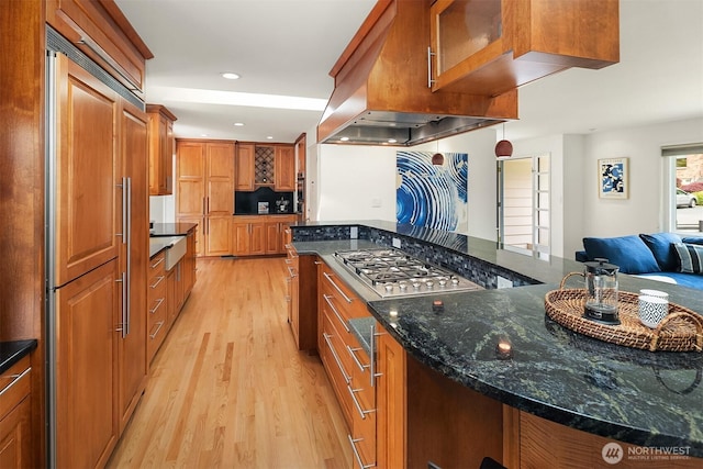 12515 2nd Ave NW, Seattle, WA 98177 - kitchen featuring paneled fridge, light wood-type flooring, brown cabinetry, dark stone counters, and recessed lighting