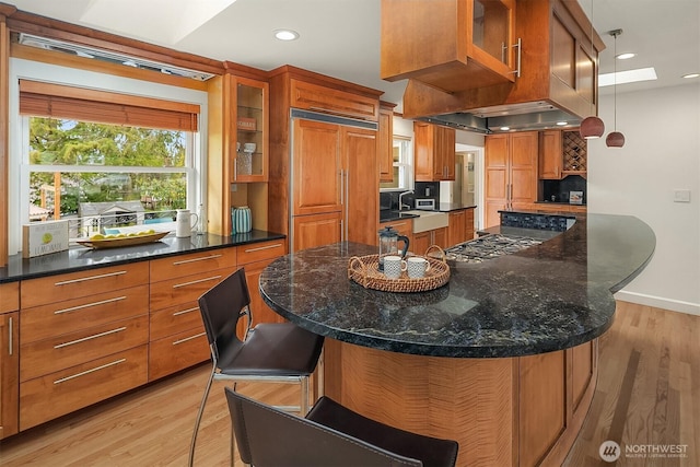12515 2nd Ave NW, Seattle, WA 98177 - kitchen featuring brown cabinetry, light wood finished floors, paneled built in refrigerator, glass insert cabinets, and recessed lighting