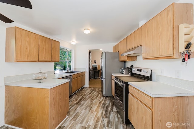 3160 SE Pierson St, Port Orchard, WA 98366 - kitchen featuring appliances with stainless steel finishes, under cabinet range hood, a sink, light wood-type flooring, and light countertops