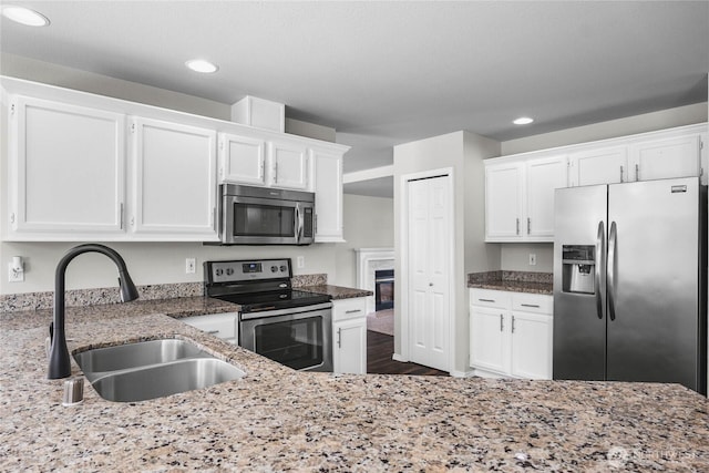 10901 194th Street Ct E, Graham, WA 98338 - kitchen featuring appliances with stainless steel finishes, a sink, white cabinetry, recessed lighting, and light stone countertops