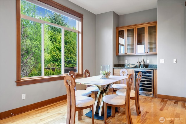 6611 Waterton Cir, Mukilteo, WA 98275 - dining area featuring wine cooler, baseboards, light wood-style floors, and a bar