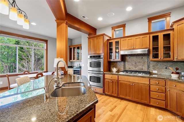 6611 Waterton Cir, Mukilteo, WA 98275 - kitchen with a sink, brown cabinets, stainless steel appliances, light wood finished floors, and decorative backsplash