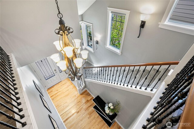 6611 Waterton Cir, Mukilteo, WA 98275 - staircase with a chandelier, wood finished floors, baseboards, and vaulted ceiling