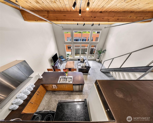 living room with wooden ceiling, beam ceiling, and a towering ceiling