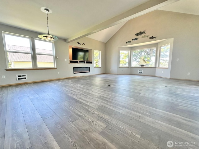 12 Diamond Dr, Pacific Beach, WA 98571 - unfurnished living room featuring wood finished floors, beamed ceiling, high vaulted ceiling, and a glass covered fireplace