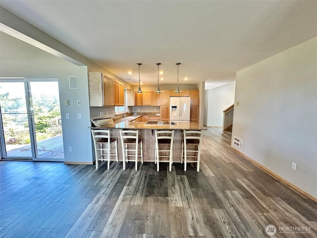 12 Diamond Dr, Pacific Beach, WA 98571 - kitchen with white fridge with ice dispenser, a peninsula, dark wood finished floors, a breakfast bar area, and recessed lighting