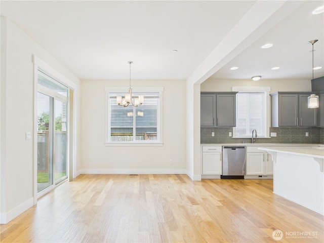 14419 45th Ln S, Tukwila, WA 98168 - kitchen featuring dishwasher, a chandelier, light wood-style flooring, decorative backsplash, and light countertops