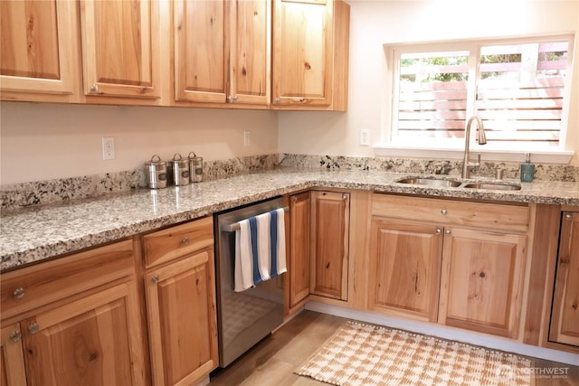 340 N Terrace Rd, Hoodsport, WA 98548 - kitchen with stainless steel dishwasher, a sink, light stone counters, light wood-style floors, and light brown cabinetry