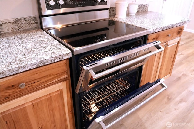 340 N Terrace Rd, Hoodsport, WA 98548 - kitchen with stainless steel electric stove, light wood-style flooring, and light stone countertops