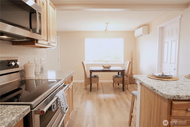 340 N Terrace Rd, Hoodsport, WA 98548 - kitchen with stainless steel appliances, an AC wall unit, light wood-style floors, and light stone countertops