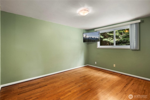 unfurnished room featuring wood finished floors and baseboards