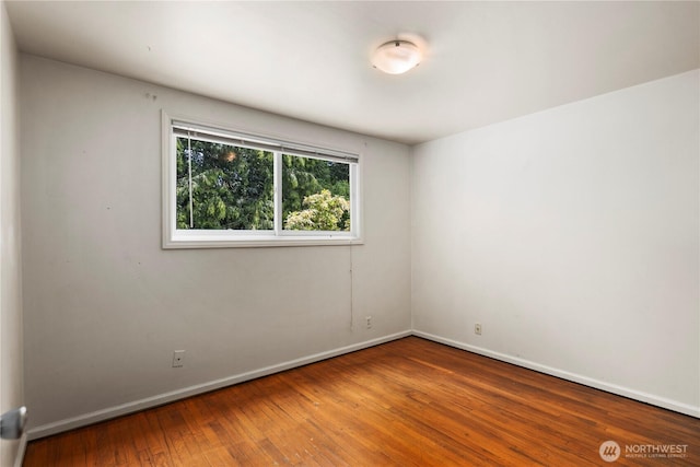 unfurnished room featuring baseboards and hardwood / wood-style floors