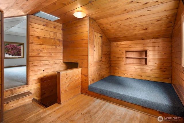 additional living space featuring vaulted ceiling, wood ceiling, wooden walls, wood finished floors, and a sauna / steam room