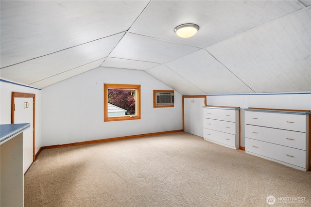 additional living space with light carpet, lofted ceiling, and baseboards