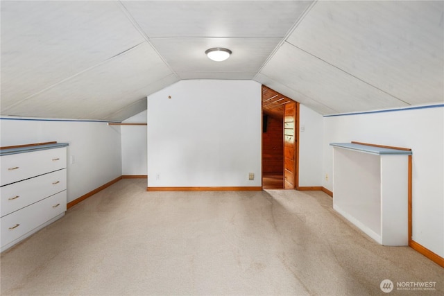 additional living space featuring carpet flooring, vaulted ceiling, and baseboards