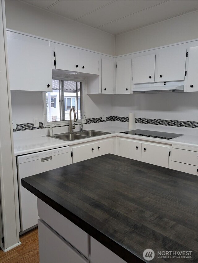2302 R St SE Unit 128, Auburn, WA 98002 - kitchen featuring under cabinet range hood, a sink, dishwasher, black electric stovetop, and white cabinets
