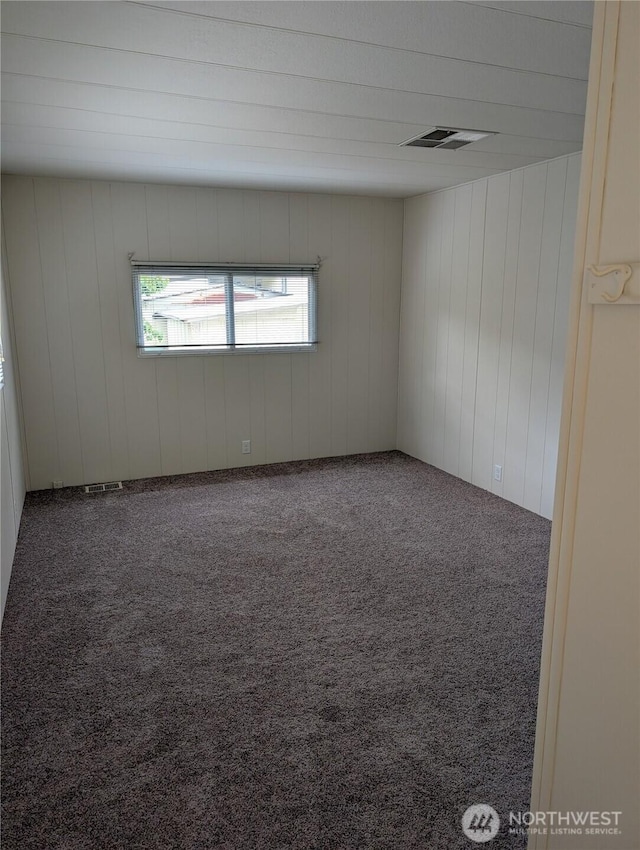2302 R St SE Unit 128, Auburn, WA 98002 - carpeted empty room with wood walls